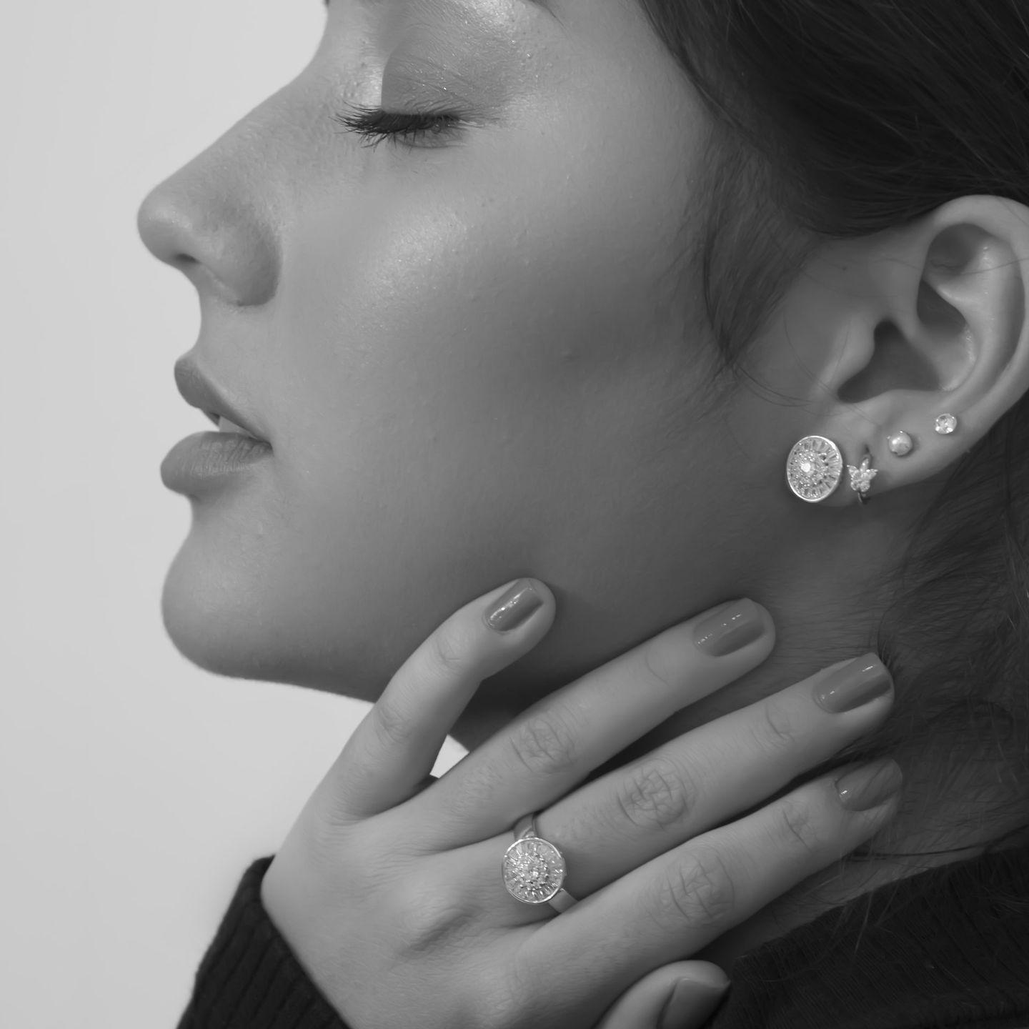grayscale photo of woman wearing silver diamond stud earrings
